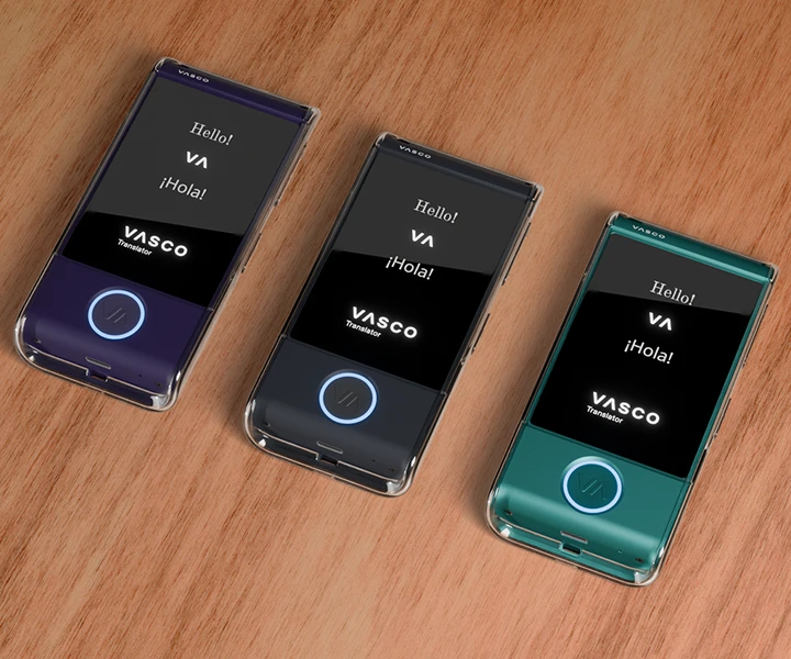 Kolme Vasco Translator M4 -laitetta pöydällä läpinäkyvissä silikonikuorissa kolmessa eri värissä, ja niiden näytöt ovat päällä ja niissä näkyy Vasco-logo ja valaistut LED-painikkeet.