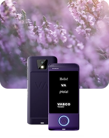 Tuotekuvassa näkyy violetti Vasco Translator -laite kahdesta kulmasta tummaa, kuvioitua kangasta vasten. Vasemmalla olevassa kuvassa näkyy laitteen takapuoli, jossa korostuvat kameran linssi salamalla sekä kohokuvioitu ”VA”-logo. Oikealla oleva laite on kuvattu edestä, ja sen valaistulla näytöllä näkyy tervehdykset 