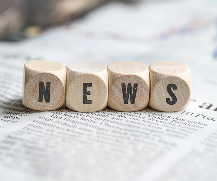 Palikat, joissa lukee ”NEWS”, makaa sanomalehden päällä.